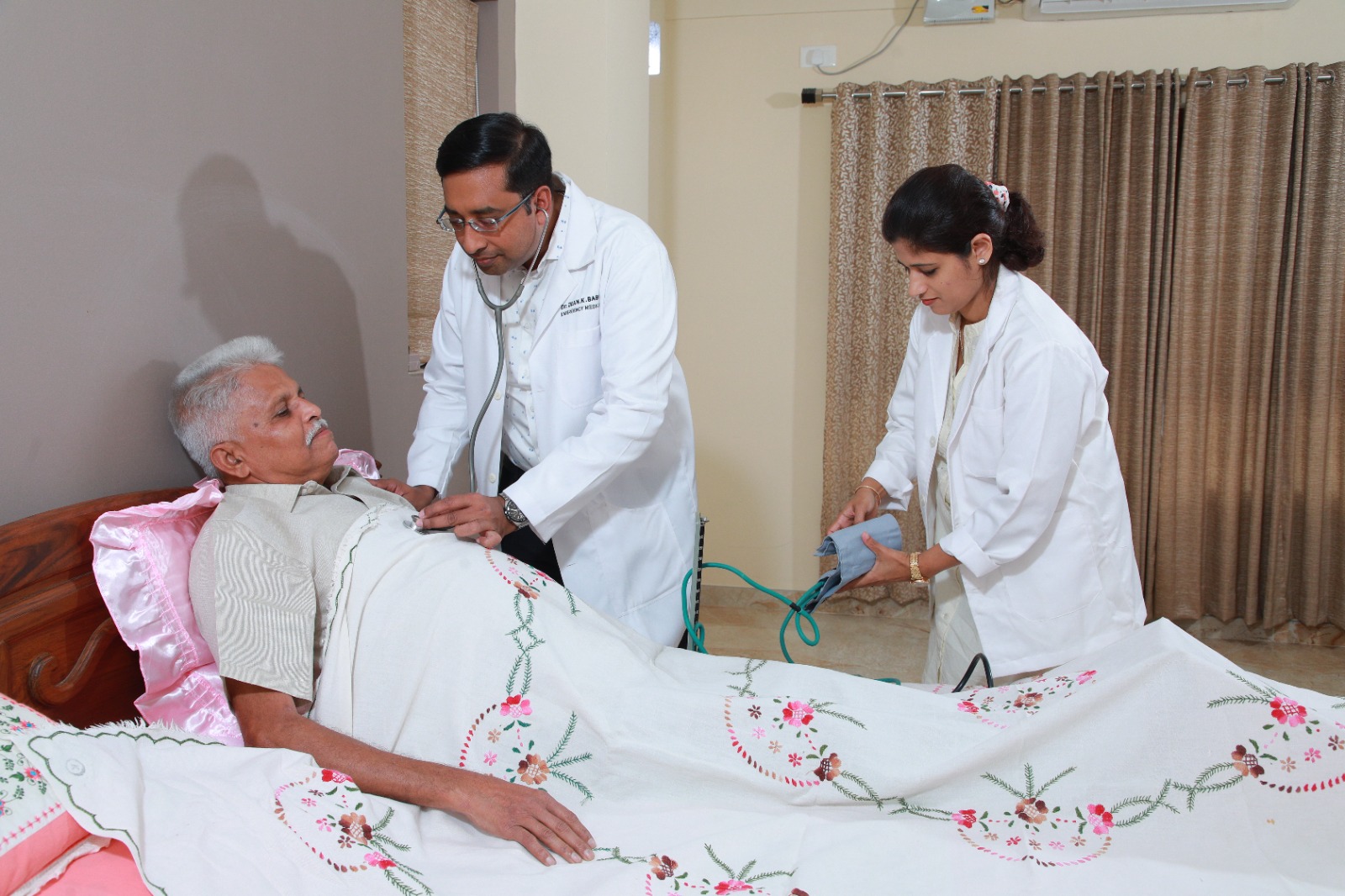 Doctors caring for an elder in bed