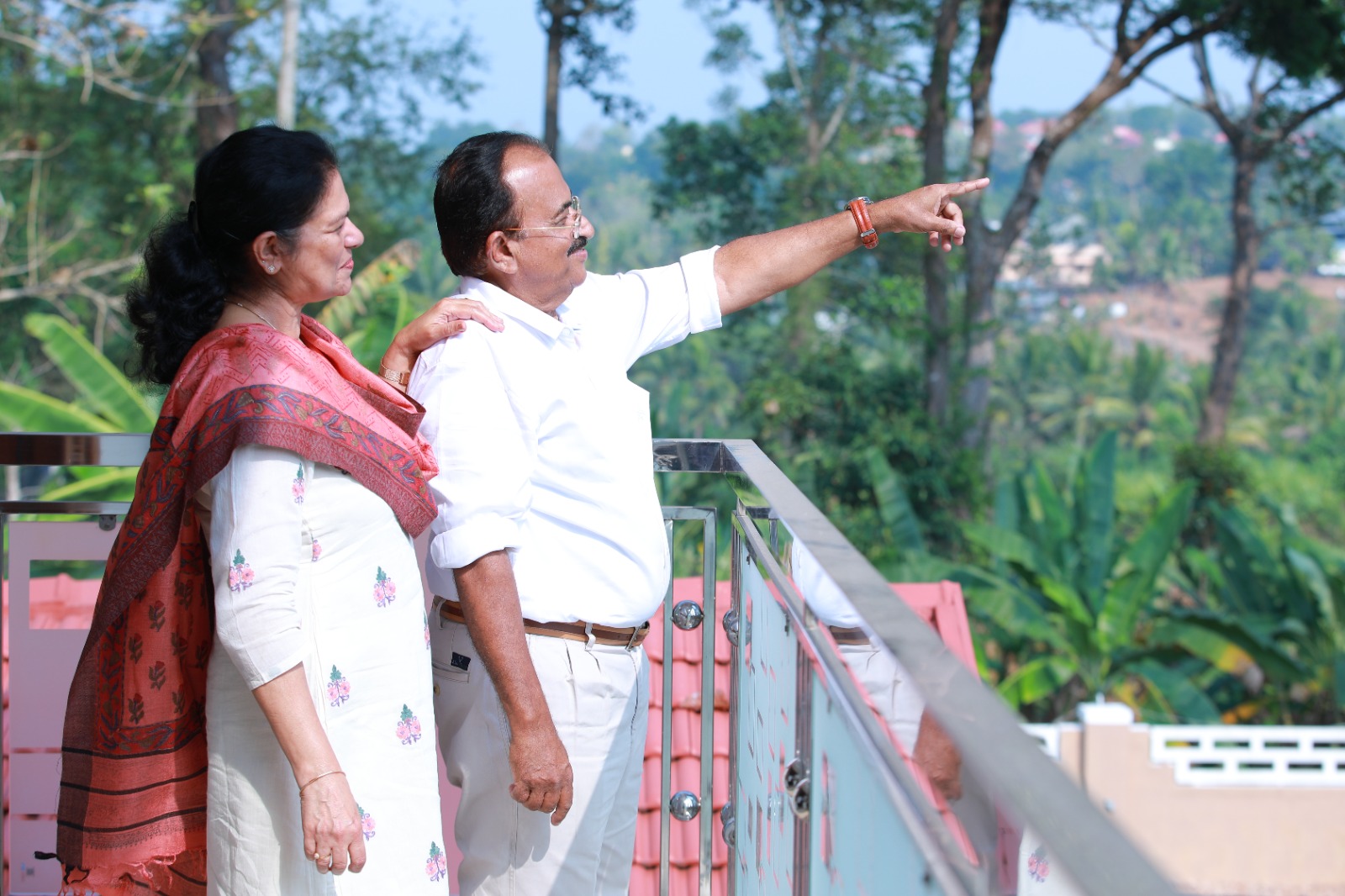 Couple looking out over greenery from a balcony